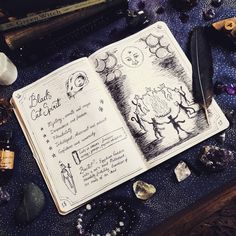 an open book sitting on top of a table filled with rocks and other items next to it