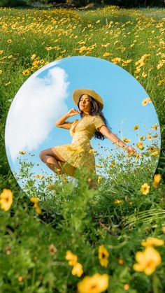 a woman in a yellow dress and straw hat is standing in a field with flowers