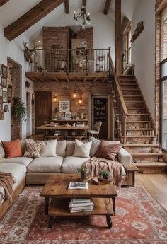 a living room filled with lots of furniture and a staircase leading up to the second floor