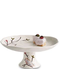 a white cake plate with two small birds on it