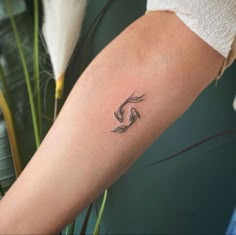 a woman's arm with a small wave tattoo on it