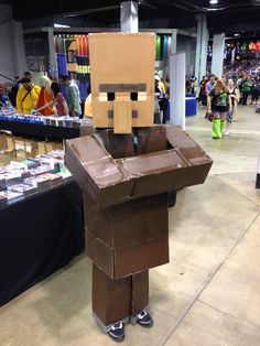 a man made out of cardboard is standing in the middle of a room with other people