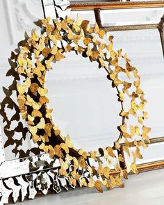 a mirror that has some gold butterflies on it