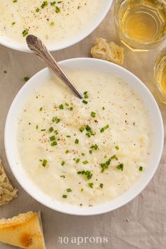 two white bowls filled with soup and bread