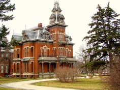 an old red brick building with a clock tower on the top and two story windows