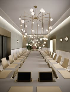 an empty conference room with long tables and laptops on each side of the table