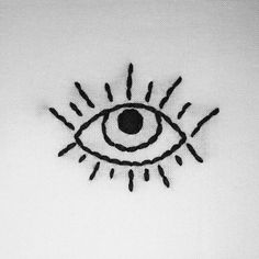 an eye drawn on the side of a piece of paper with black thread in it