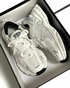 a pair of white sneakers in a box