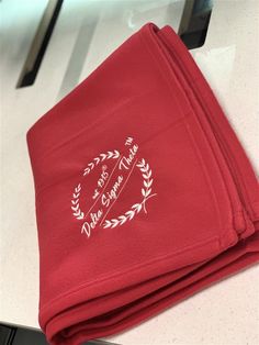 three folded red towels sitting on top of a counter