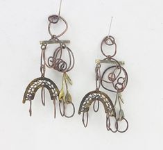 two pairs of metal earrings hanging from hooks