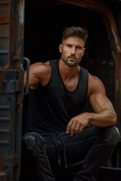 a man in black shirt sitting on the back of a truck