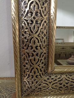 an ornate gold framed mirror sitting on top of a table