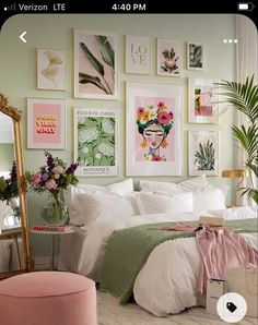 a bedroom with green walls and pictures on the wall above the bed, along with a pink ottoman