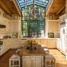 a large kitchen with wooden floors and an arched glass ceiling over the island countertop