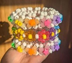 a hand holding a bunch of colorful bracelets