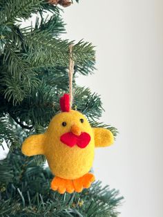 an ornament hanging from a christmas tree with a chicken on it's head