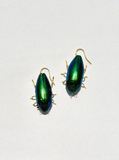 Real beetle earring, cruelty-free. Brass pin legs and inlay. 14k gold-plated sterling silver French hook. Sold as an individual earring. Please note that our earrings are made from real beetles. There will be slight variances in size, shape, and color from the photos shown online. Beetle Earring, Castle Core, Jewelry Goals, Beetle Earrings, Romantic Castle, Trend 2025, Bug Earrings, Manifest Board, Pinterest Predicts