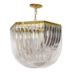 a chandelier hanging from the ceiling with clear glass and gold trimmings