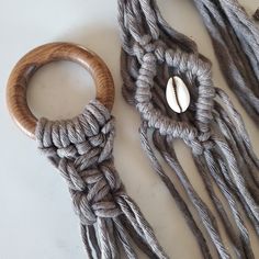 two pieces of rope and a wooden ring on a white surface with shells in the middle