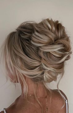 a woman with blonde hair in a messy updo