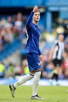 a soccer player holding his hand up in the air