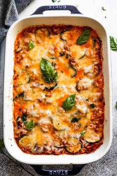 a casserole dish with meat, cheese and spinach in it on a table