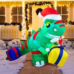 a large inflatable dinosaur with a santa hat on it's head is outside