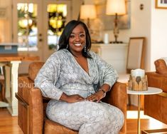 a woman sitting in a chair smiling at the camera