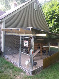 a chicken coop with two chickens in it