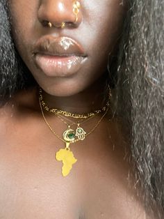 a close up of a woman with gold jewelry on her neck and nose piercings