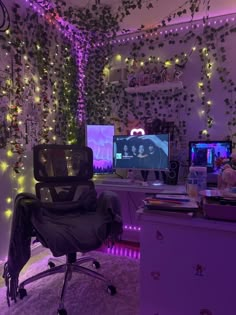 a room with three computer monitors and lights on the wall, all decorated in purple