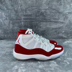 Elevate Your Sneaker Game With These Stylish And Iconic Air Jordan 11 Retro High Cherry Sneakers. The Shoe Features A High Top Design, Making It Perfect For Any Occasion. It Comes In A Classic White Color With Varsity Red And Black Accents, Giving It A Sleek And Modern Look. The Sneaker Is Made By Jordan, A Trusted Brand In The Athletic Shoe Industry. It Is A Men's Shoe And Is Available In Size 12. The Air Jordan 11 Retro High Cherry Is A Must-Have For Any Sneaker Enthusiast, And It Is Sure To T Cherry Sneakers, Red Jordans, Jordan Shoes Retro, Retro 11, Jordan Red, Air Jordan 11 Retro, Athletic Shoe, Jordan 11 Retro, Men's Shoe