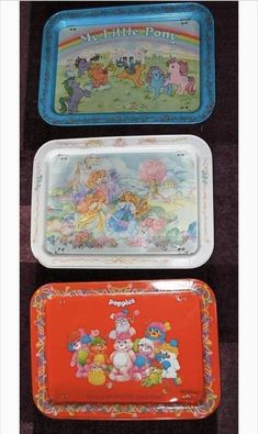 three plastic trays with cartoon characters on them