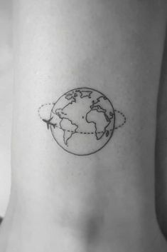 a small world map tattoo on the side of a woman's stomach, with an airplane flying over it