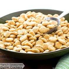 a bowl filled with ranch seasoned oyster crackers on top of a green towel next to a spoon