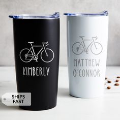 two personalized tumblers sitting next to each other on a white table with coffee beans