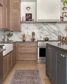 a kitchen with marble counter tops and wooden cabinets, along with an area rug on the floor