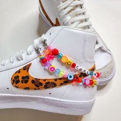 a pair of white sneakers with colorful beads on them