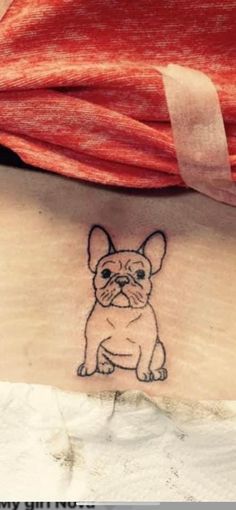 a small tattoo of a dog on the side of a woman's left arm