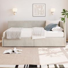 a bed sitting in the middle of a bedroom next to a plant