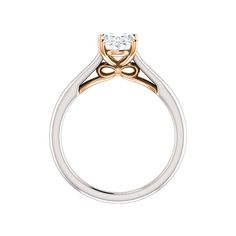 a white and yellow gold engagement ring with a single diamond in the center, on a white background