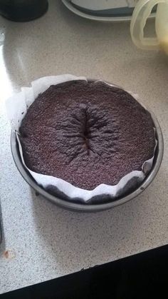 a chocolate cake sitting on top of a counter next to a plate with the words, mes troups de voisins moint demande d'apper le dessert