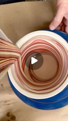 a person is making a bowl out of paper