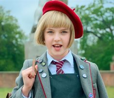 a young boy dressed in an old fashioned uniform