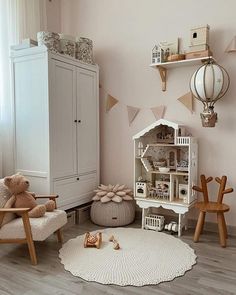 a child's room with pink walls and white furniture, including a teddy bear