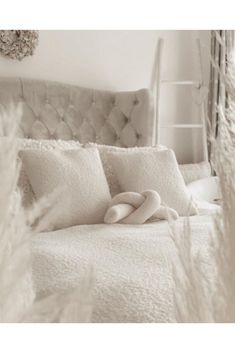 a bed with white sheets and pillows on it