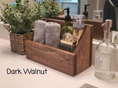 a wooden box with soap, lotion and other items in it sitting on a bathroom counter