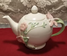 a tea pot with flowers painted on it