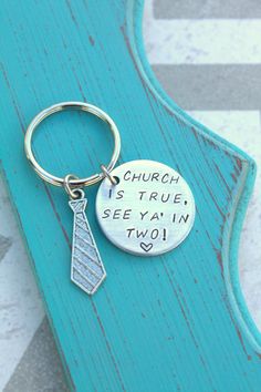 a metal keychain with a tag that says church is true, see ya in two