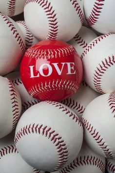 a red ball with the word love on it surrounded by white baseballs